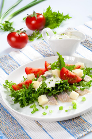 Селедочный салат с помидорами, картофелем и сметанным соусом